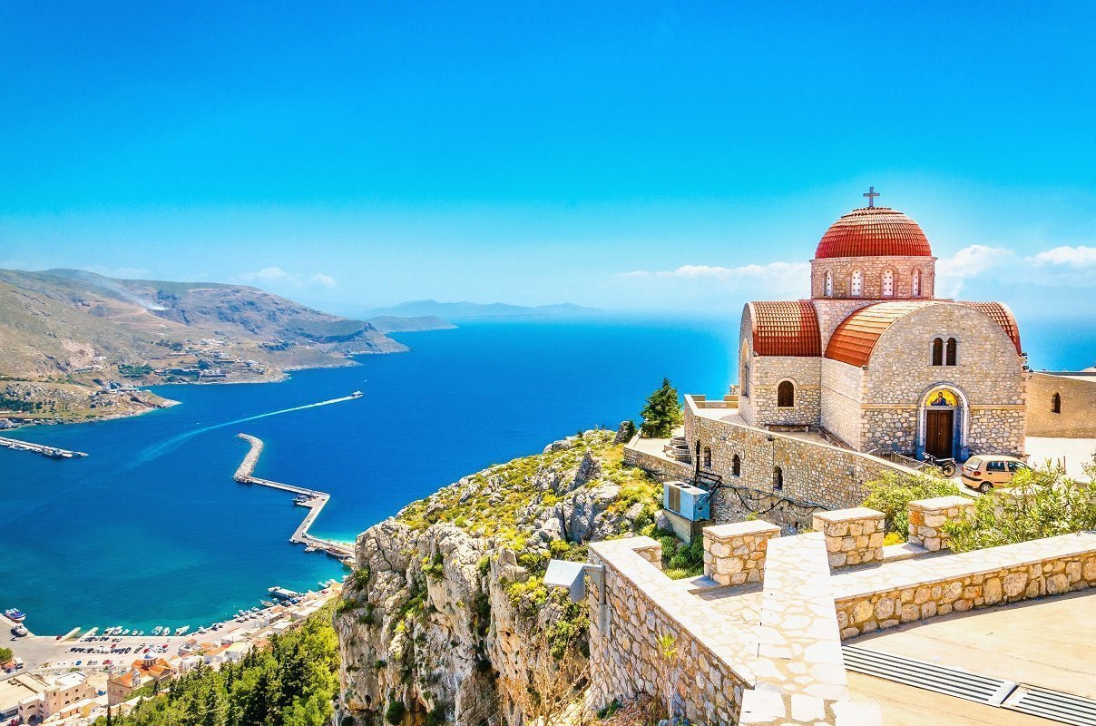 Amazing view on remote church with red roofing on the Cliff of the sea, Greece